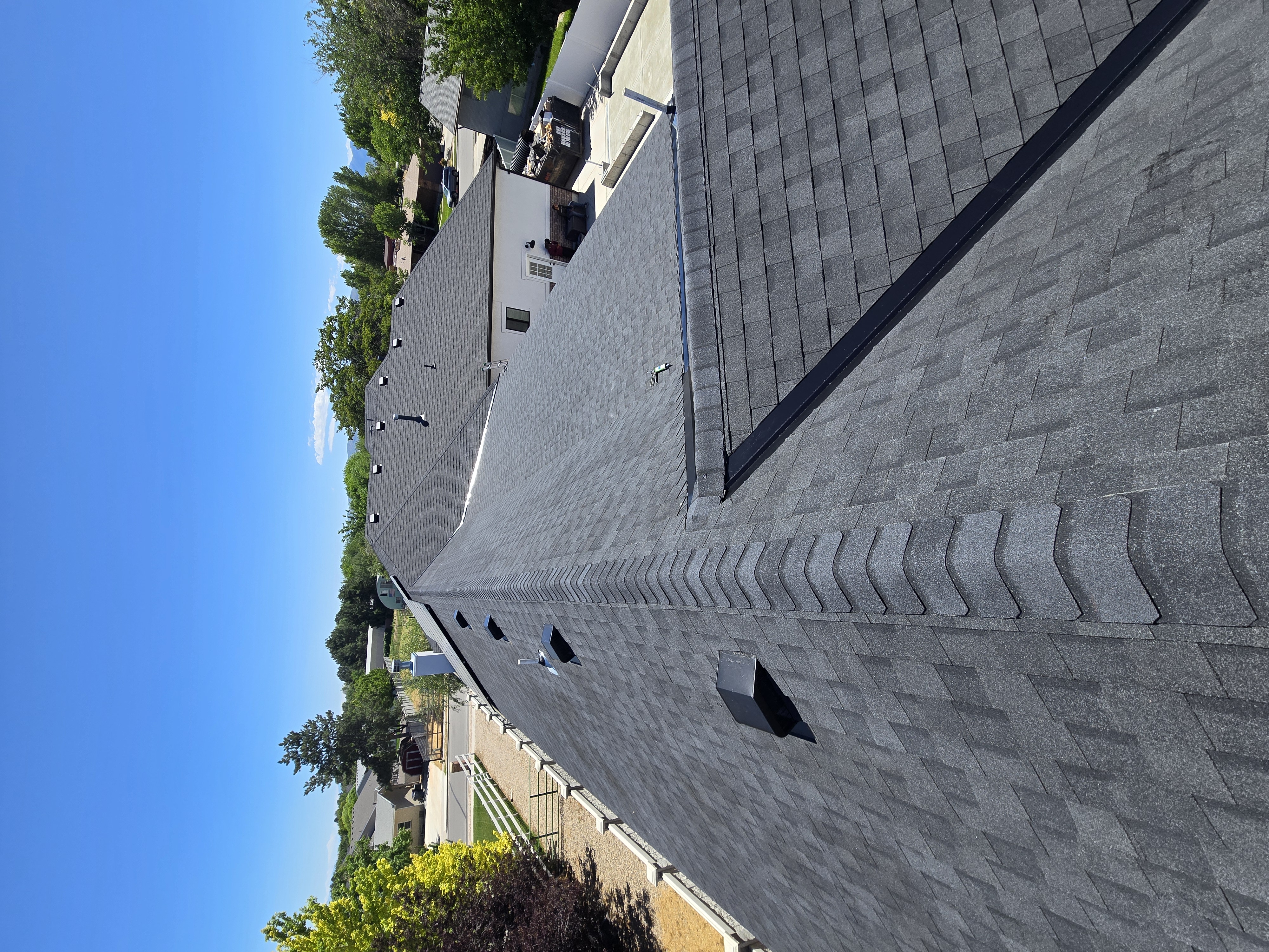 Looking down a completed charcoal shingle roof