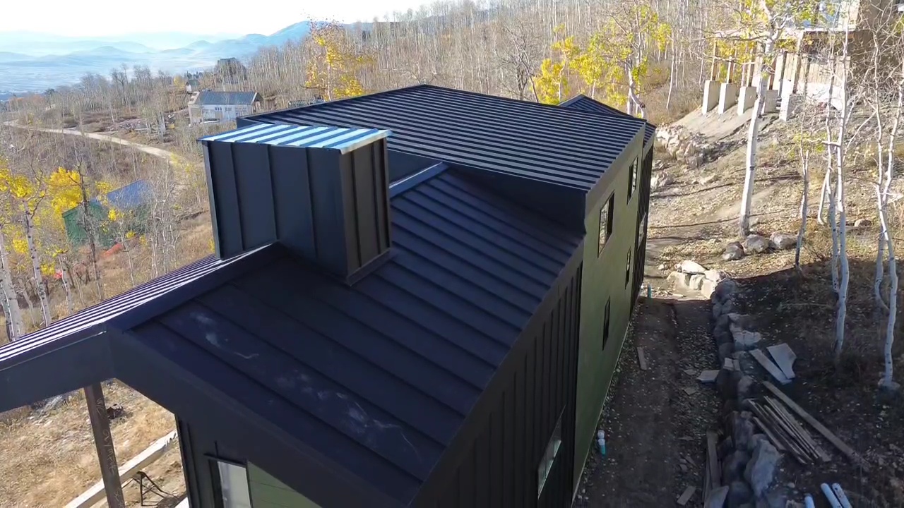 Aerial of a black standing seam metal roof on a mountain home
