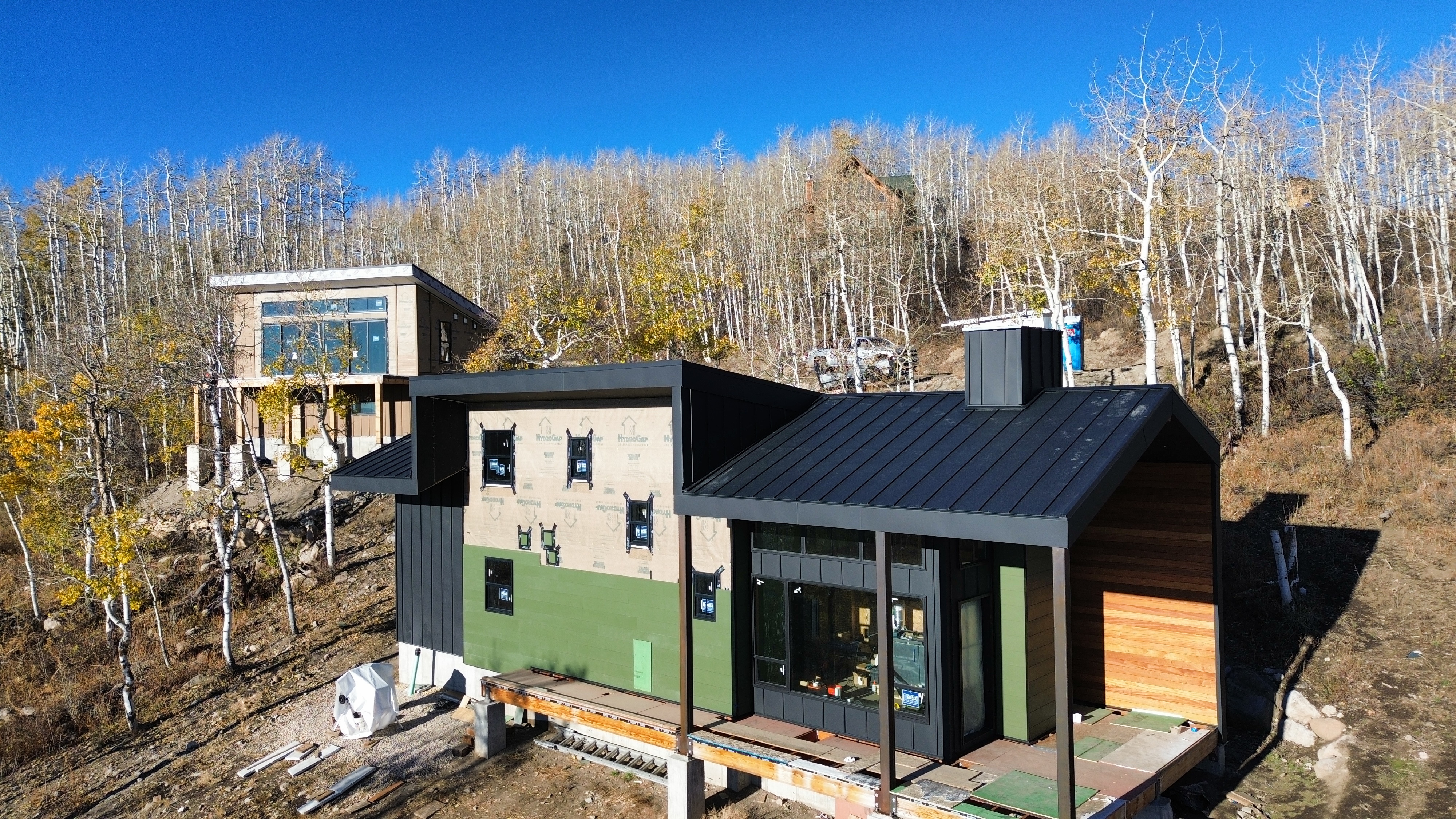 Hillside home with new siding and a black metal roof