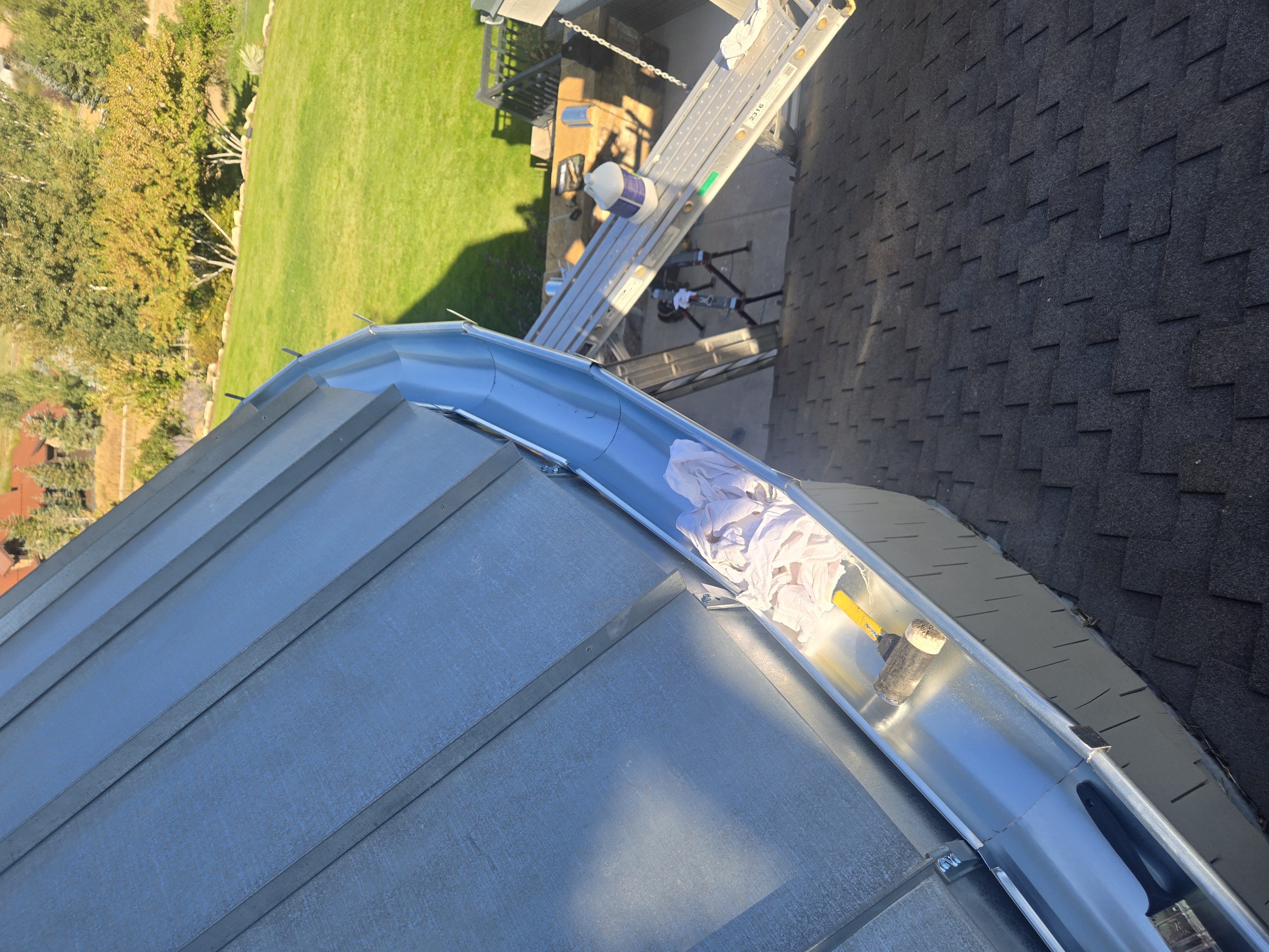 Gutter installation along a curved metal roof